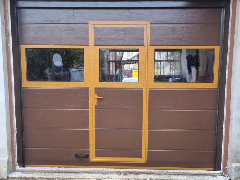 Ușă de garaj secțională maro cu ușă pietonală integrată și hublouri