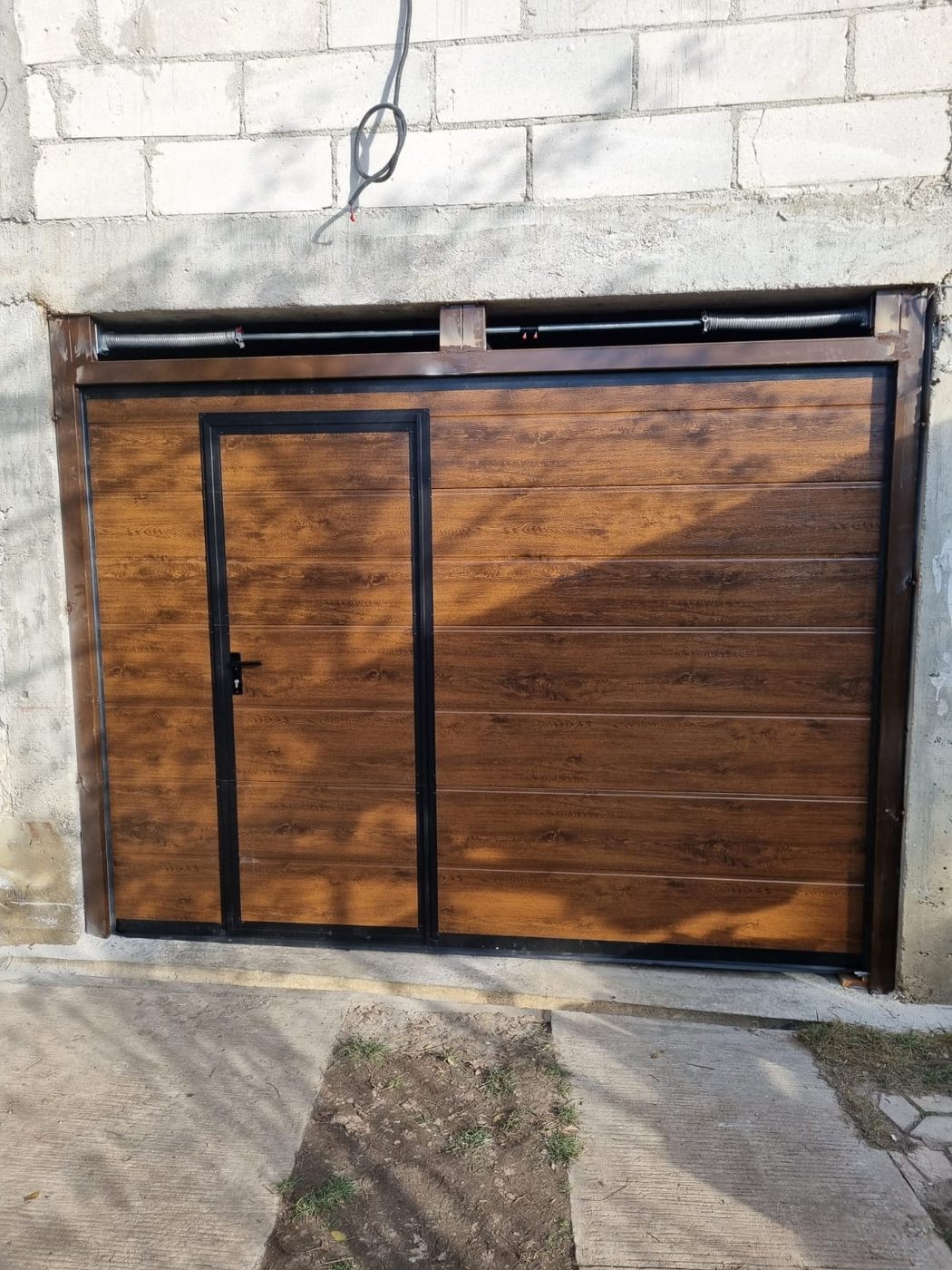 Ușă de garaj secțională nuc cu ușă pietonală integrată și arcuri de torsiune