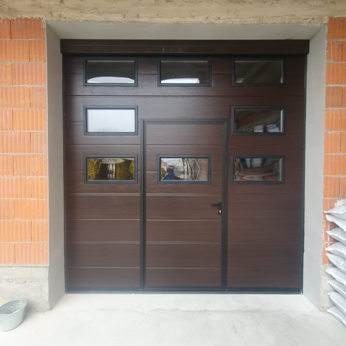 Ușă de garaj secțională wenge cu hublouri și ușă pietonală integrată